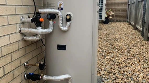 Heat pump hot water system installed on a brick home in Queensland, illustrating common hot water problems