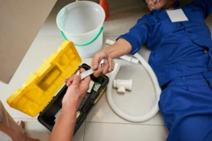 Blocked drains Gold Coast plumber clearing a drain blockage using professional plumbing tools inside a residential home