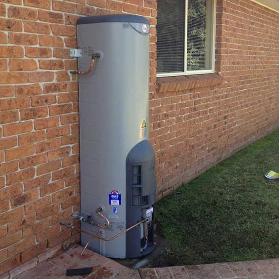 Gas hot water system installed outside brick home in Gold Coast by EVR Plumbing