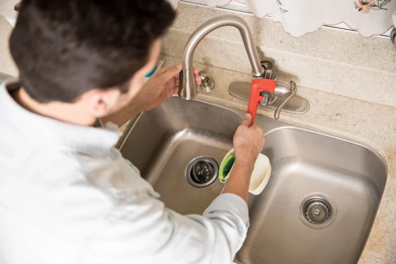 Clearing blocked kitchen sink drain using plumbing tools