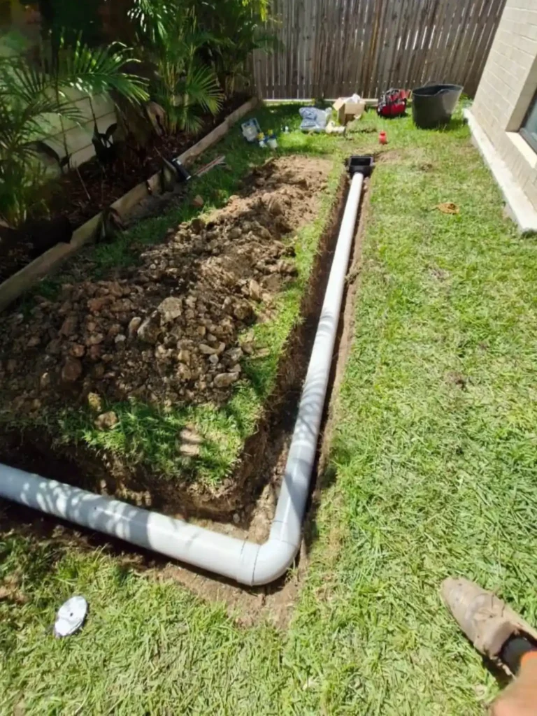 EVR Plumbing wastewater treatment and septic tank drainage pipe installation in trench before backfilling