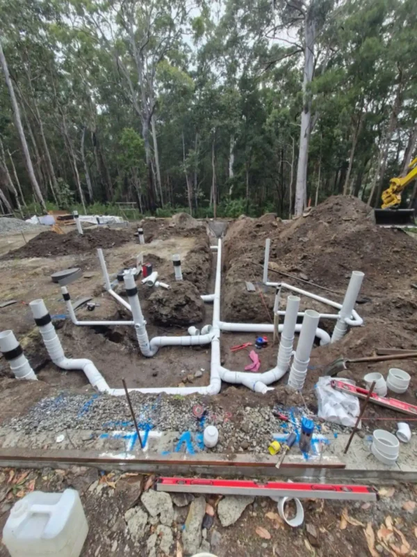 EVR Plumbing septic tank and wastewater treatment underground drainage system installation with PVC pipe layout before backfilling