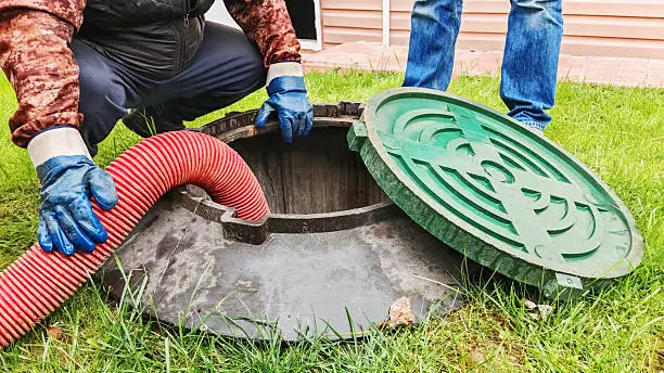 Septic tank maintenance in Queensland with technicians checking an underground wastewater system and service hose for early warning signs.