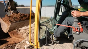 Excavator trenching work with machine bucket moving soil for residential excavation and drainage preparation