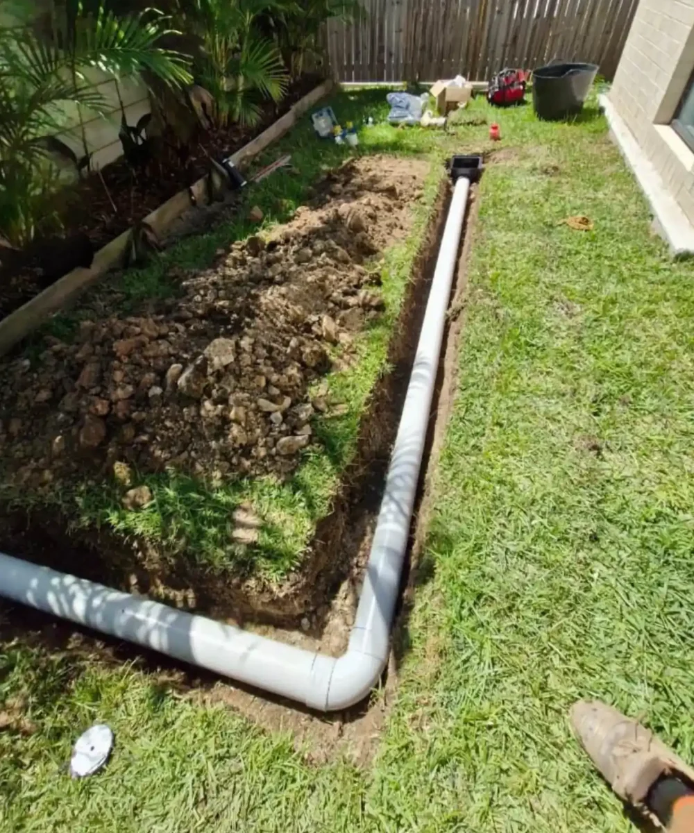 EVR Plumbing wastewater treatment and septic tank drainage pipe installation in trench before backfilling